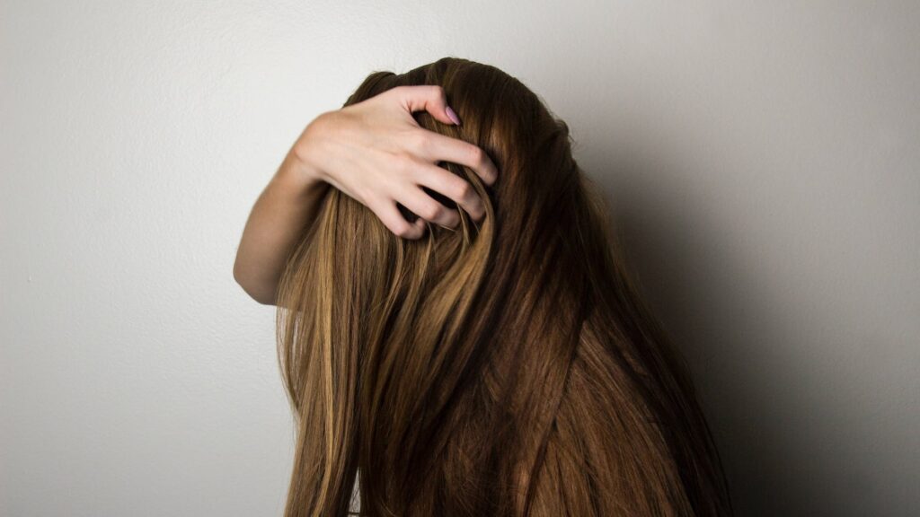 photo of woman covering face with her hair